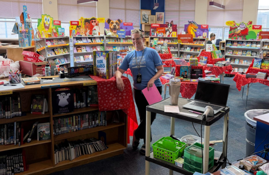 Mrs. Jackson, the librarian, posing in front of book fair tables