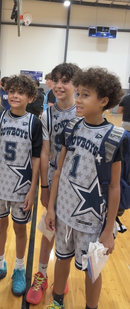 Three boys smiling on a basketball court in their cowboys uniform