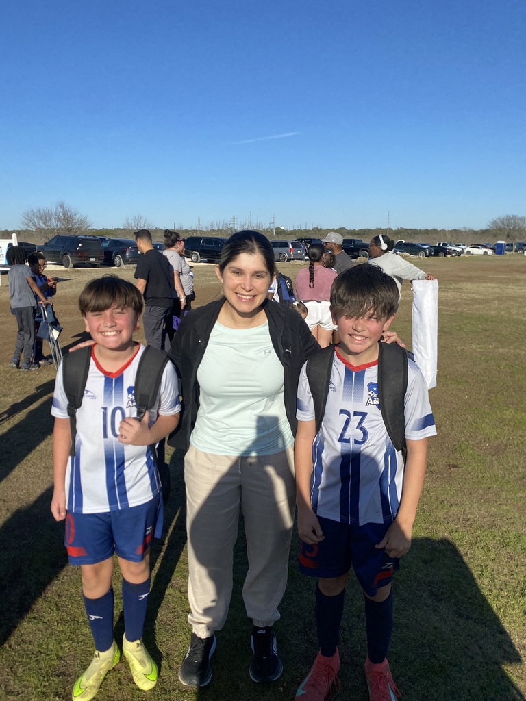 Mrs. Mendez on a soccer field with two boys in soccer uniforms
