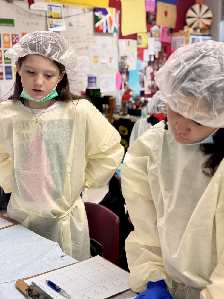 Two student students working together in their operating costumes on a review