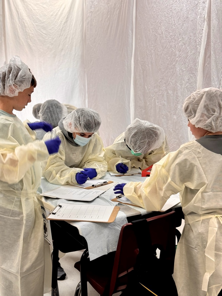 A few students working together at a table in their operating costumes