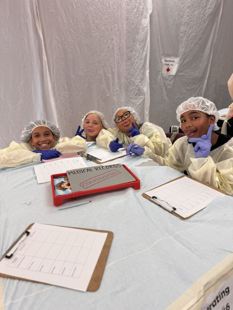 A few students posing at a table wearing operating costume costumes
