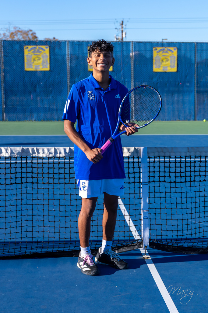 student holding a tennis raquet