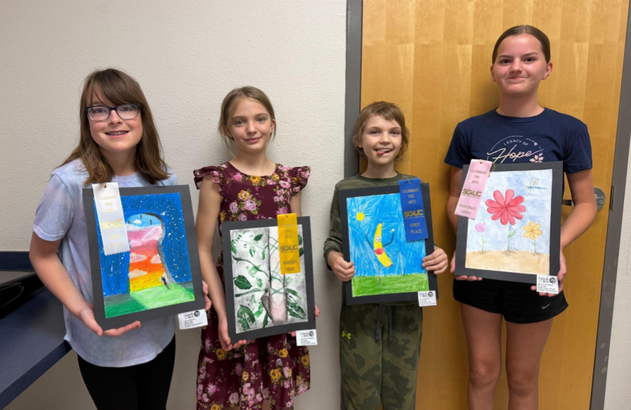 students posing with their awarded ribbons and artwork from the Celebrate the Arts show