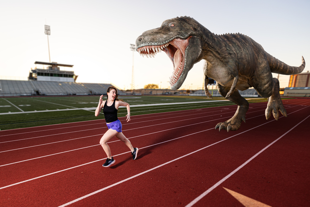 girl getting chased by dinosaur
