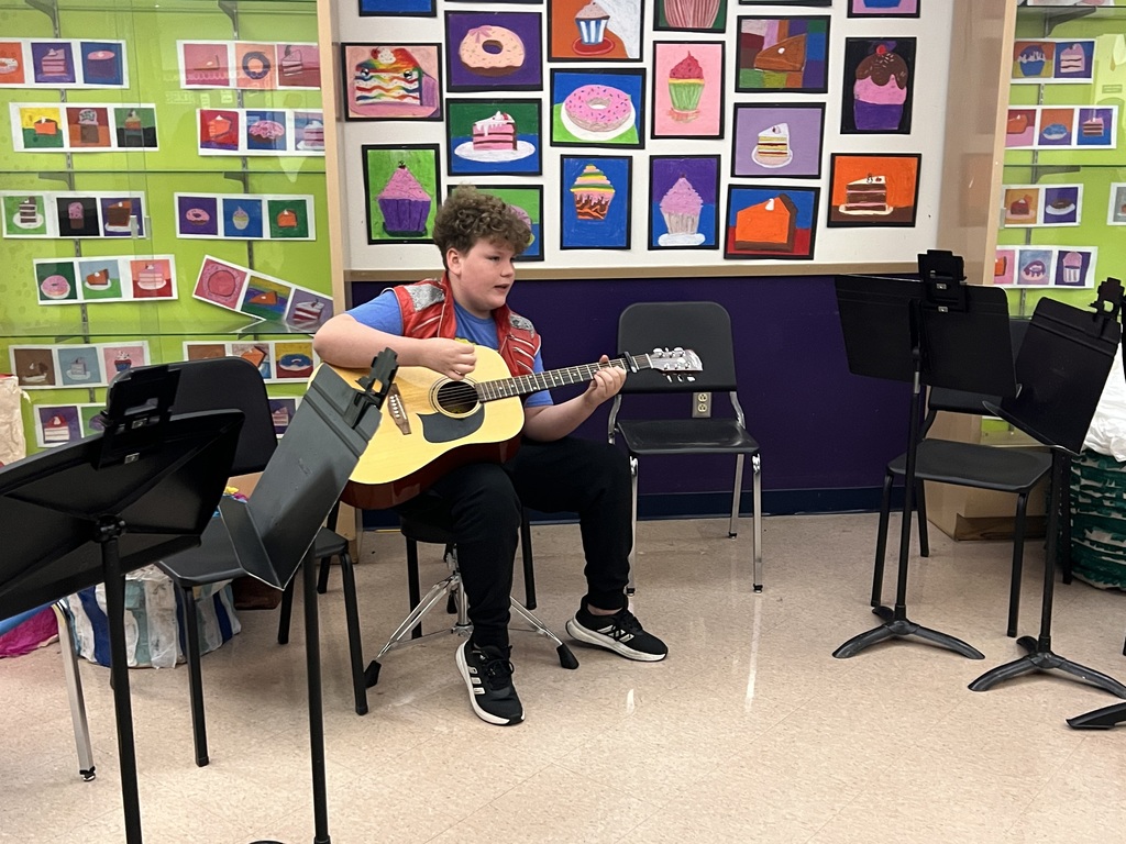 5th grade boy playing guitar and singing