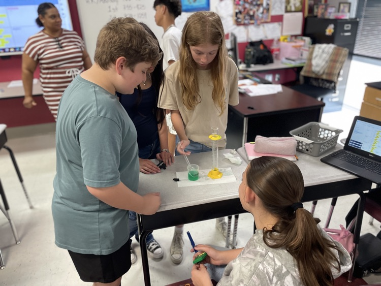 Students measuring with test tubes and drop
