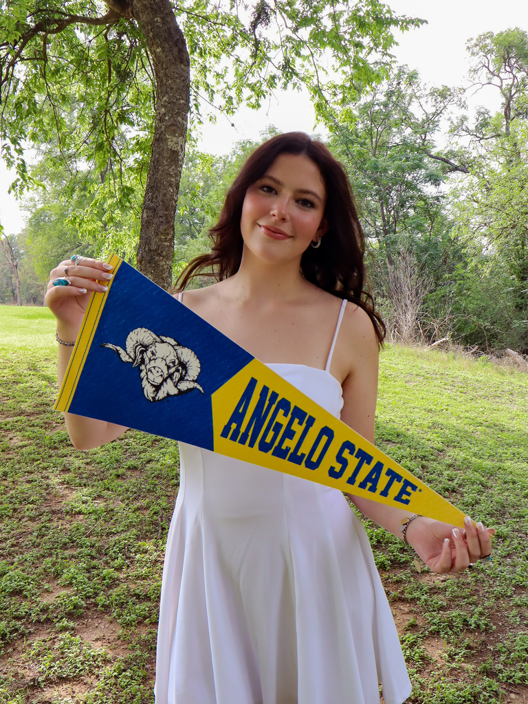 Student holding angelo state sign
