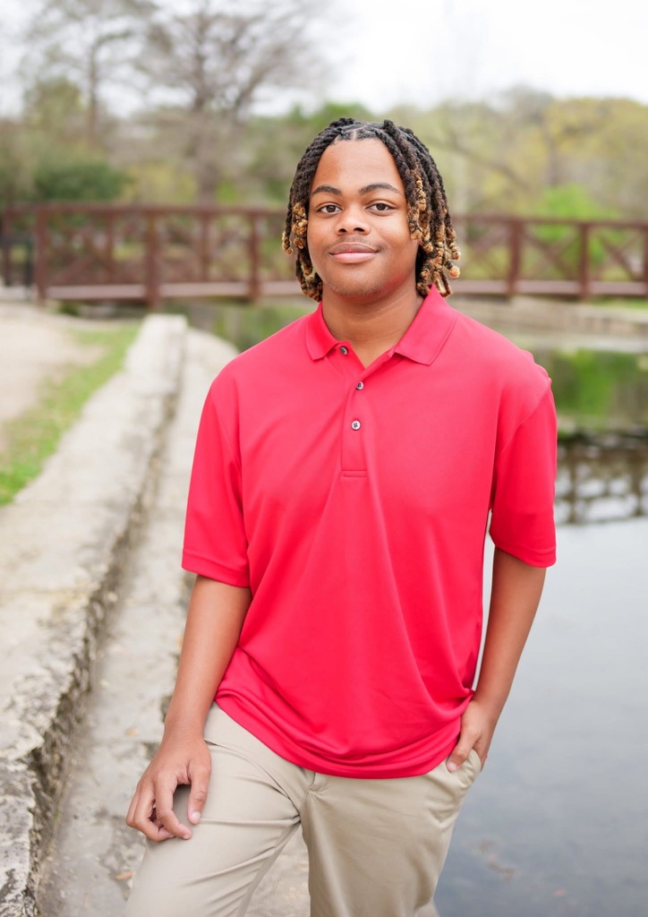 student in red by a body of water