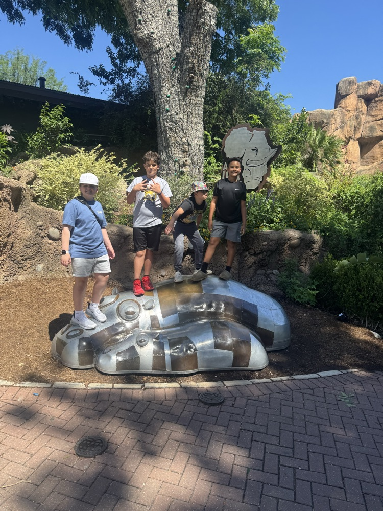 For boys posed on a hippo statue
