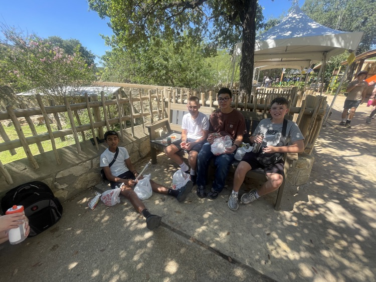 boys sitting in the shade eating lunch