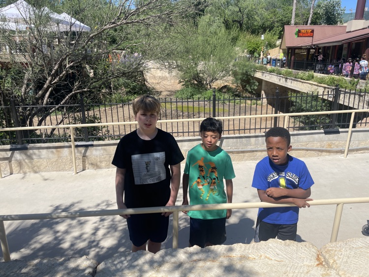 three boys posing in a sidewalk way