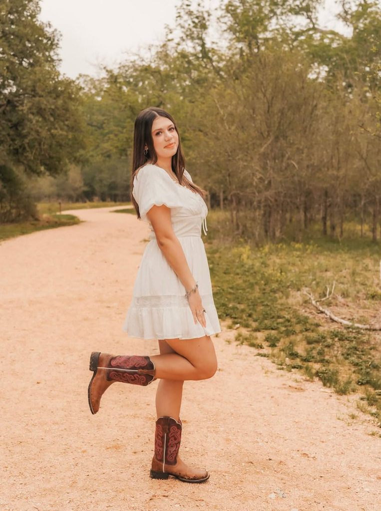 student in dress and cowboy boots