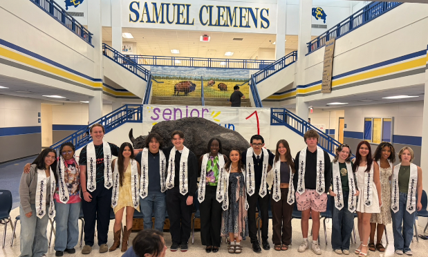 high school seniors stand in samuel clemens high school with their ib stoles draped over their shoulders