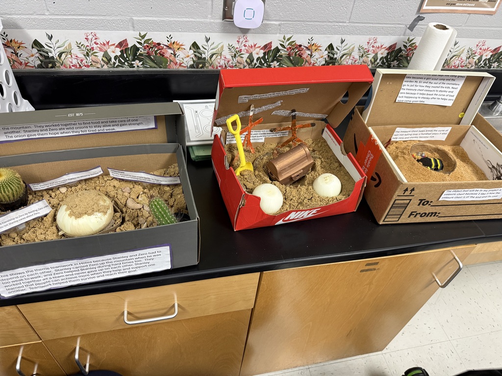 close up of 3 shoe box models of a scene in the book Holes