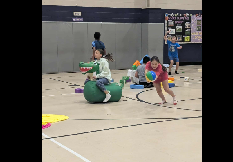 girl riding a blow up dinosaur