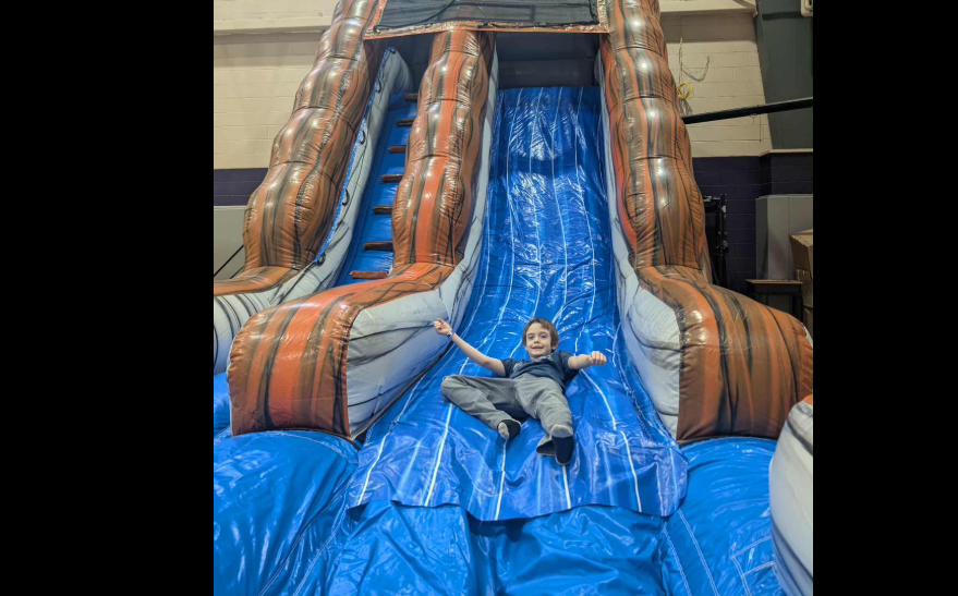 boy sliding down bouncy house