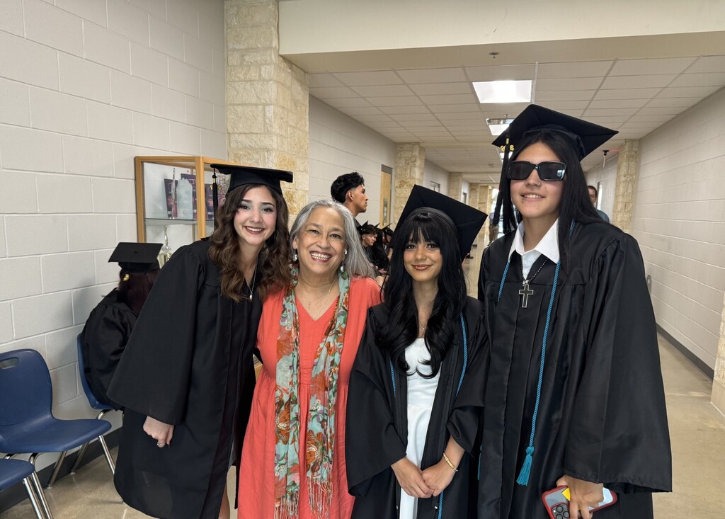 teacher with 3 female graduates about to cross the stage