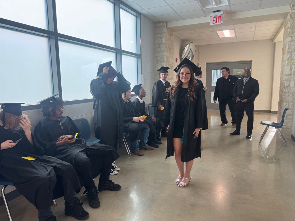 a female student posing for a photo and all the peers and two teachers around