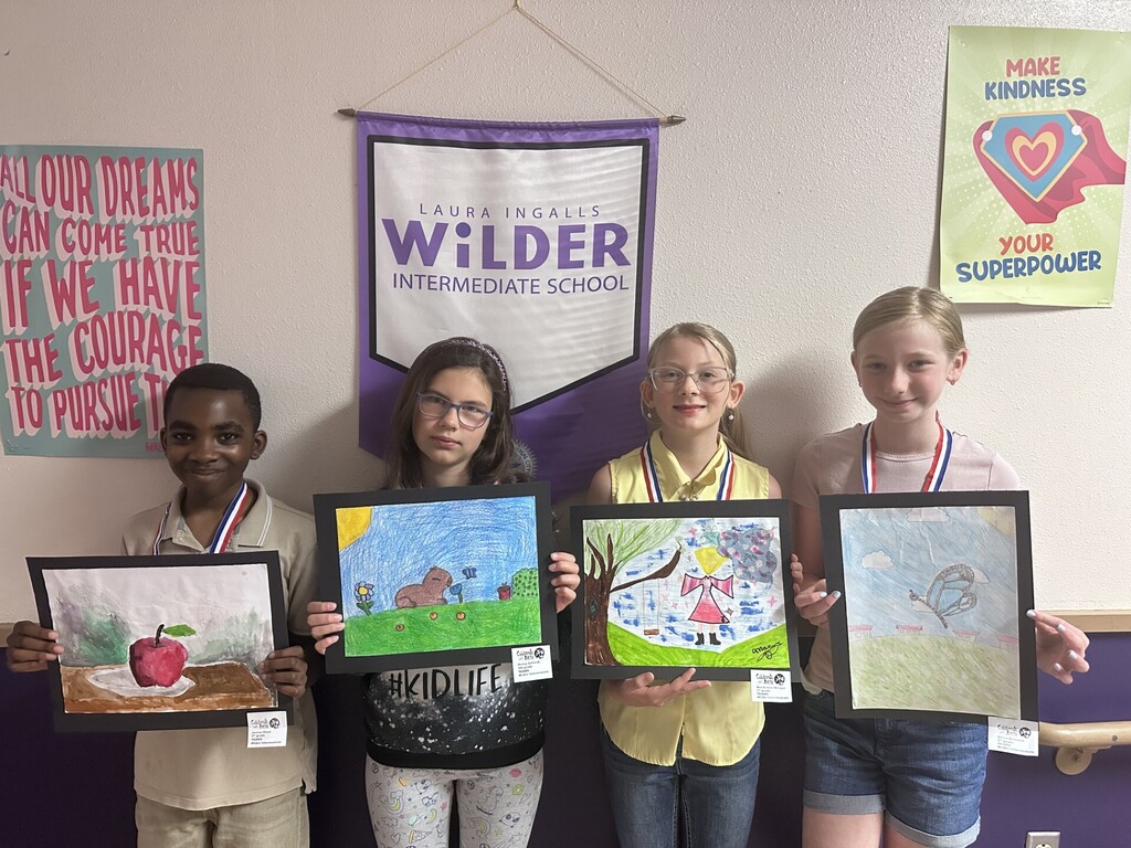 4 students holding up artwork