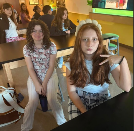 two girs holding up a peace sign