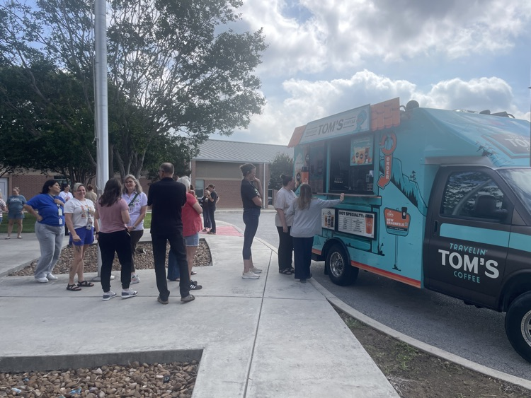 staff lined up for coffee and Toms coffee truck