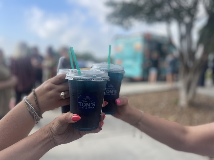 three arms holding blue drinks together