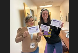 two ladies holding up certificates 