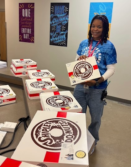 Staff holding donuts