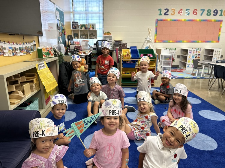 Classroom of students wearing hats and smiling