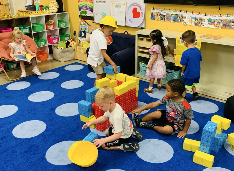 Students sitting on rug in classroom