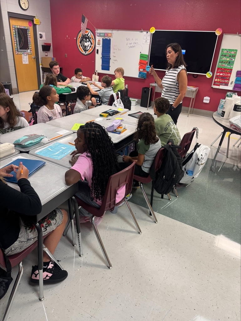 teacher speaking with students in a classroom