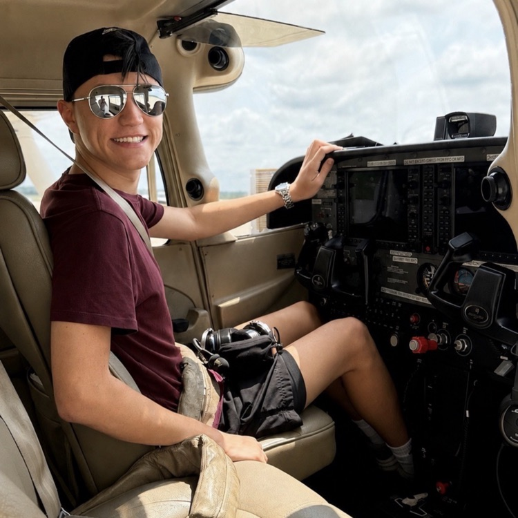 person in glasses sitting in a plane