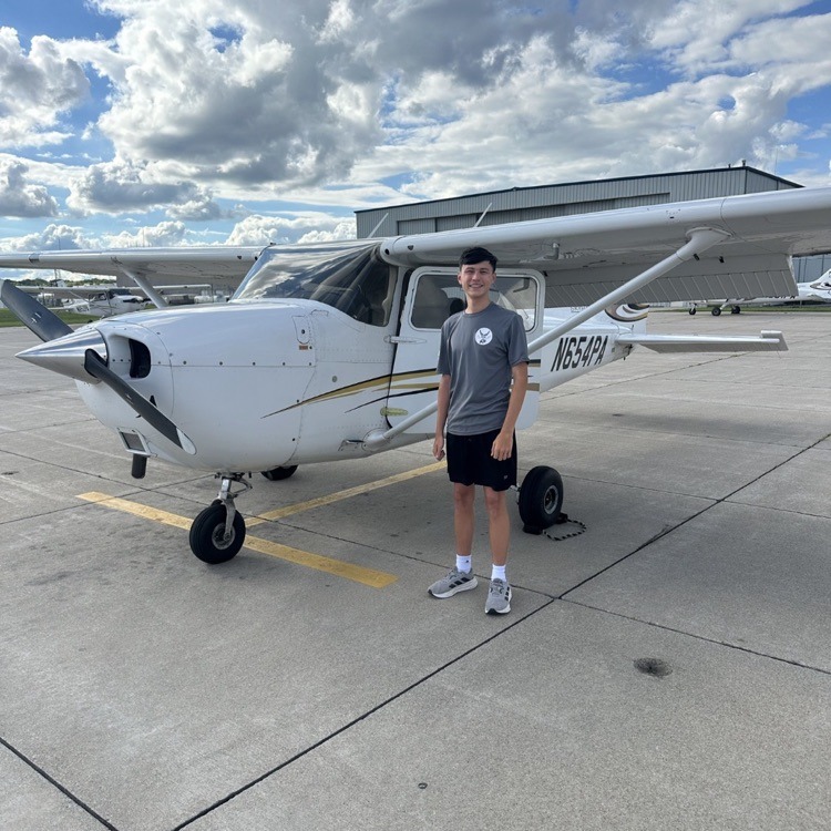 person in grey standing next to a plane