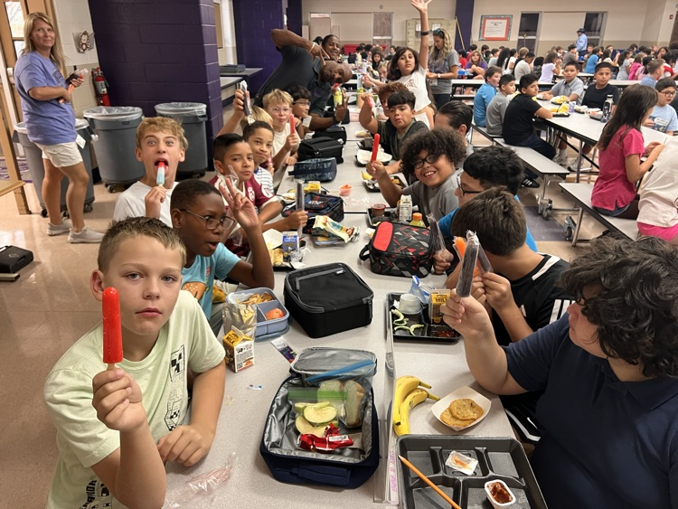 boys holding up popsicles in cafe