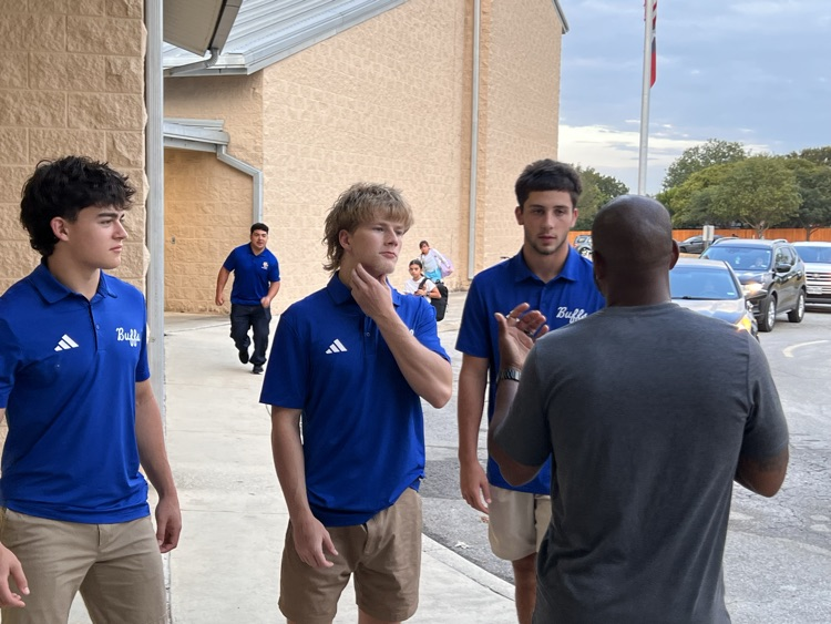 football coach talking to 3 football players