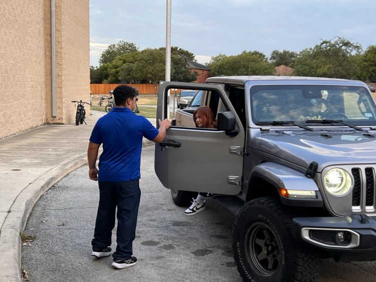 football player opening car door for student