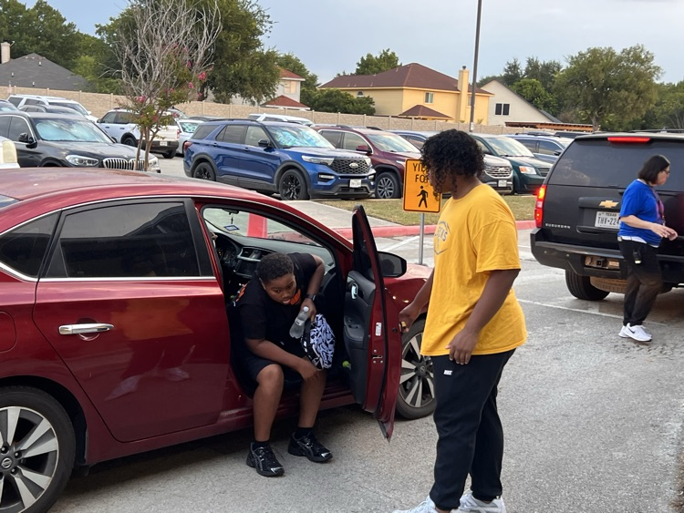 Clemens football player opening car door for a student