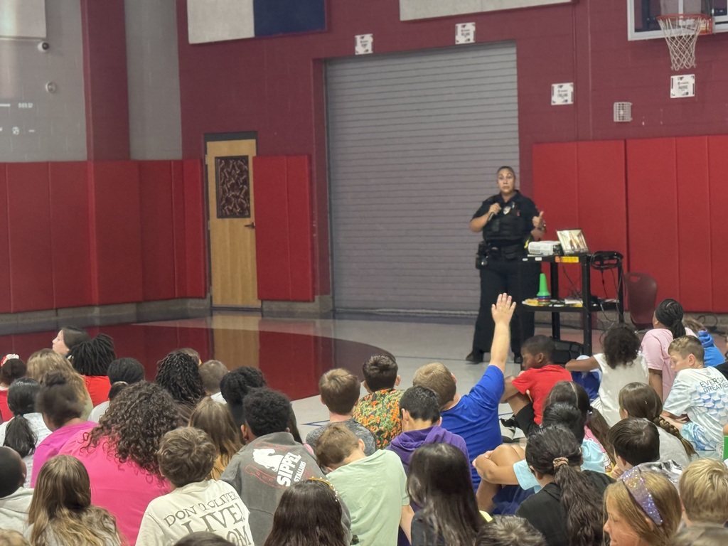 Police sergeant speaking to student during assembly