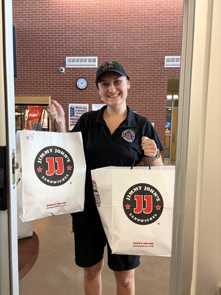 Worker holding bags of food.