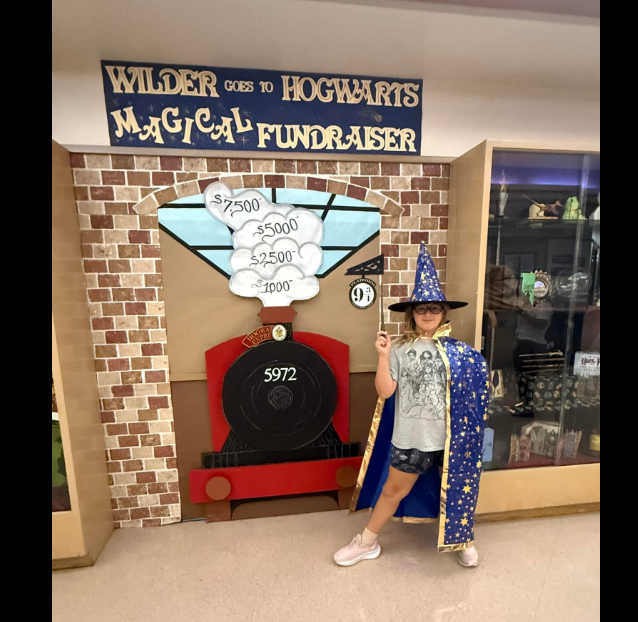 student dressed as a wizard next to Harry Potter decorations