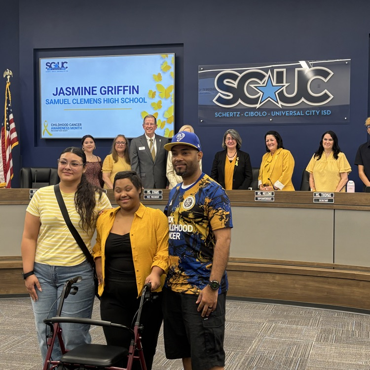 family smiling in front of board members