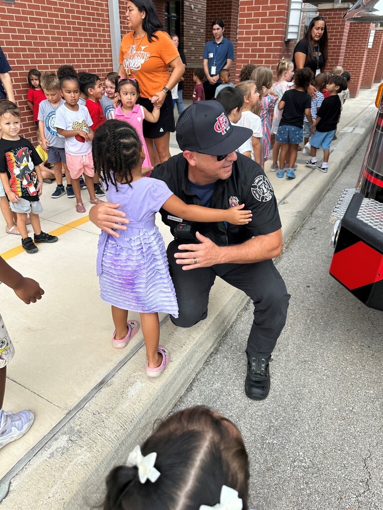 Fireman hugging student