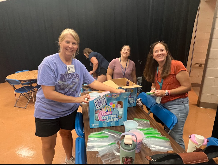 PTC volunteers sorting out cotton candy into bags and smiling at camera