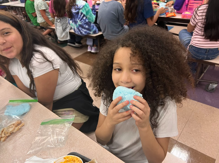 5th grade girl eating cotton candy at lunch table