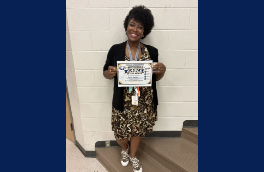 picture of Ms. Bartay holding her Most Valuable Eagle certificate