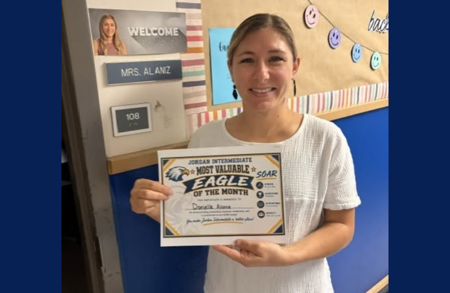 picture of Mrs. Alaniz holding her Most Valuable Eagle certificate