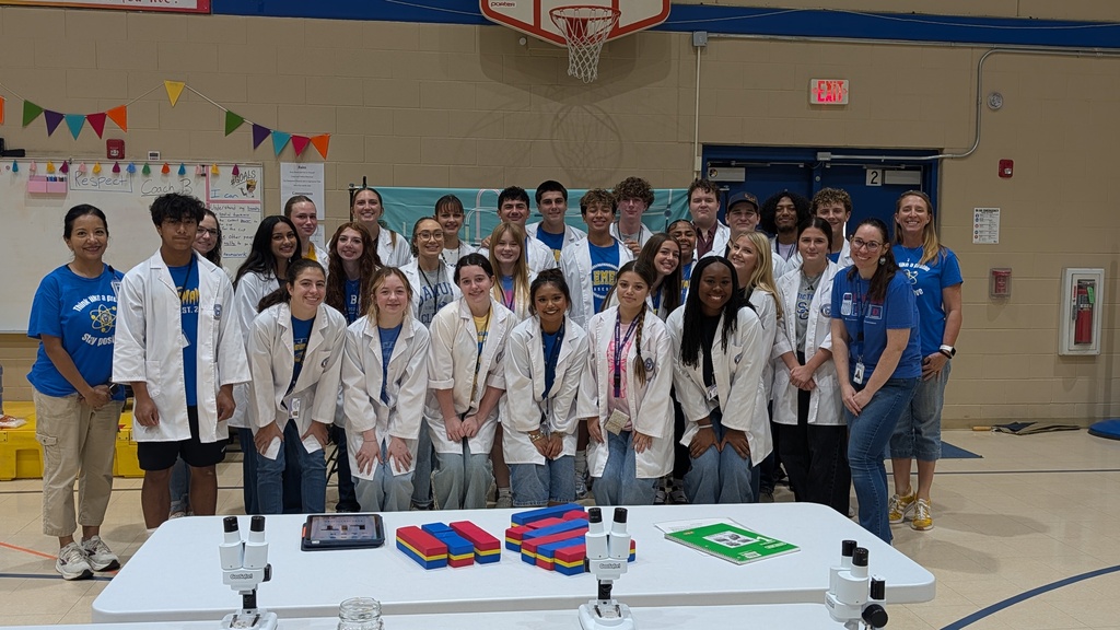 students in white lab coats smiling