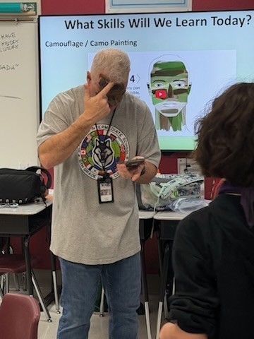 mr. jones demostrating  painting camouflage on hisself