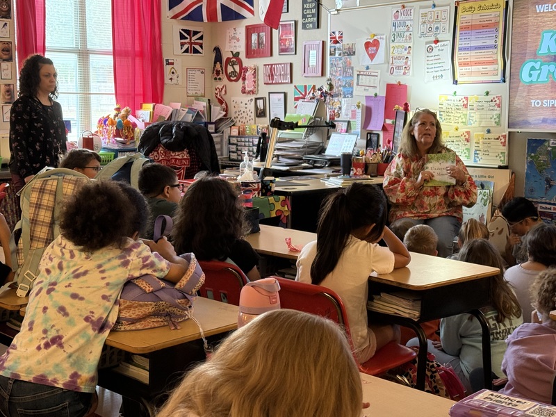 Marquis Stakes (far left) listens as Grettler reads their collaboration to Sippel students.